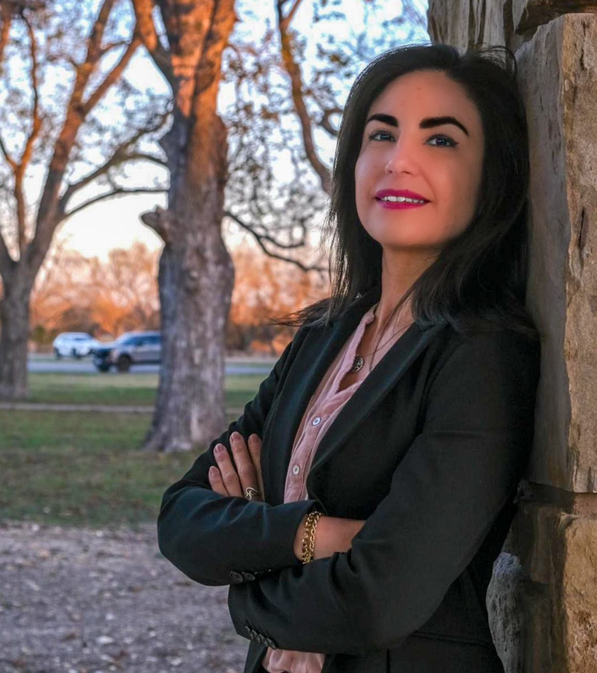 Monica Hererra, Co-Founder of Leora leaning against a wall