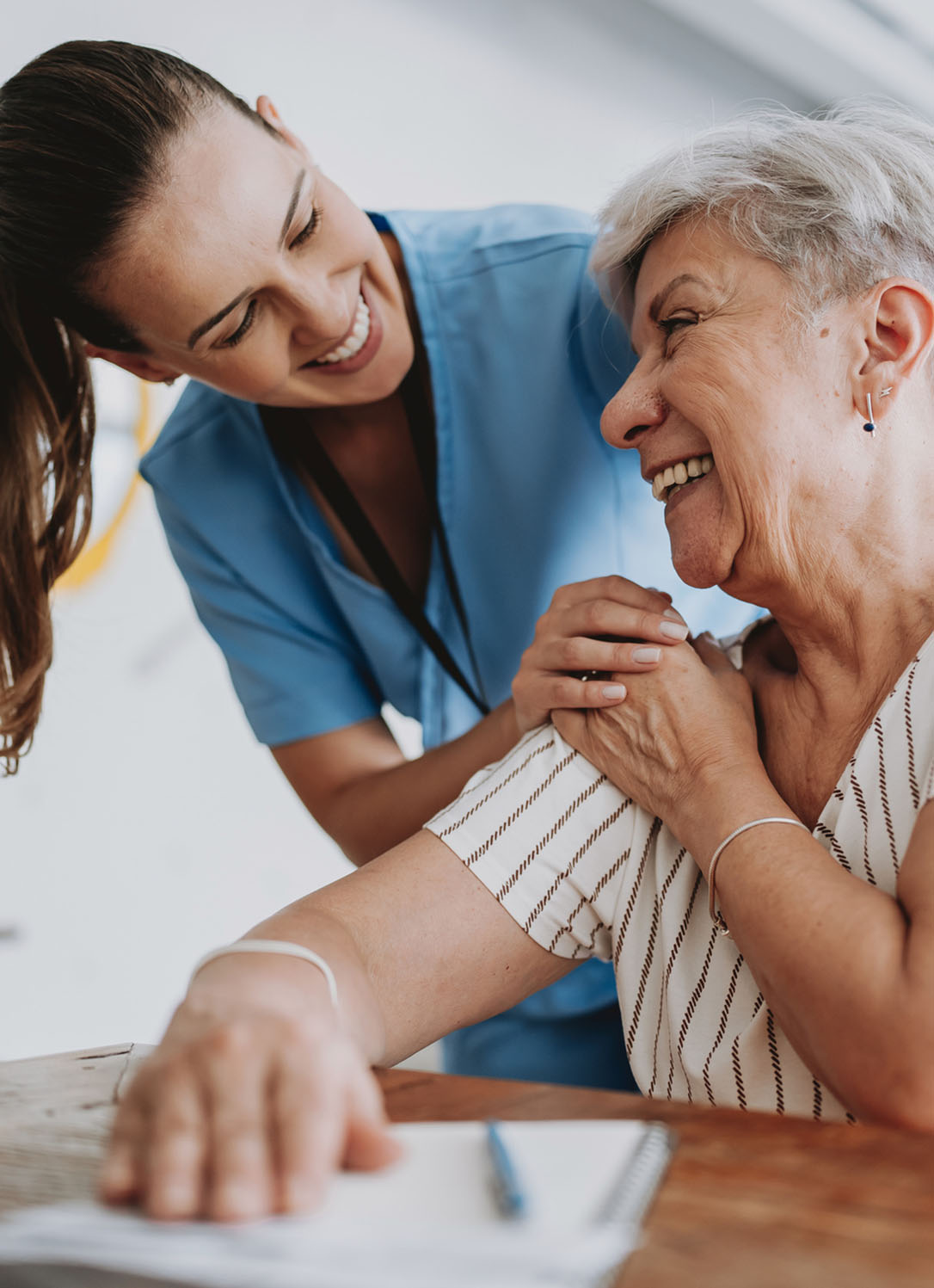 A happy case manager helps a patient fill out paperwork at home
